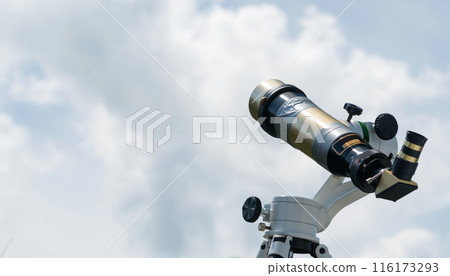 Brass telescope against cloudy sky background. 116173293