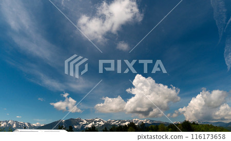 Snowy mountains under partly cloudy sky. Snowy mountains under partly cloudy sky. 116173658