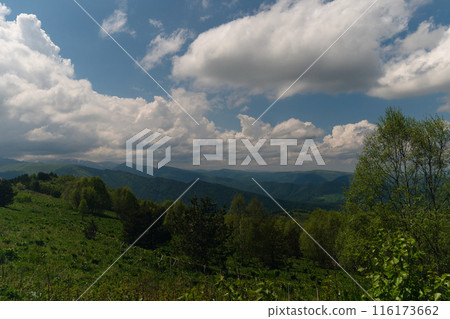 Mountainous landscape with clouds overhead. Mountainous landscape with clouds overhead. 116173662