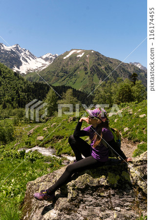 Girl posing on rock with alpine view in the background. 116174455