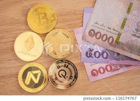 Various kinds of cryptocurrency token coins with Thai Baht banknotes on wooden table. Conceptual shot of business and financial items for trading. Various kinds of cryptocurrency token coins with Thai Baht banknotes on wooden table. Conceptual shot of business and financial items for trading. 116174767