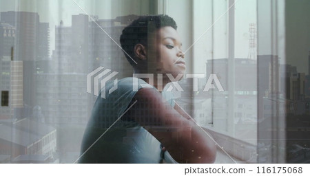 Image of african american woman looking through window over cityscape 116175068