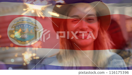 Composite image of waving costa rica flag over happy caucasian woman celebrating with sparkler Composite image of waving costa rica flag over happy caucasian woman celebrating with sparkler 116175396