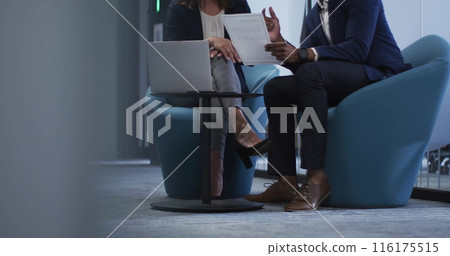 Image of caucasian team leader and african american colleague reviewing documents 116175515