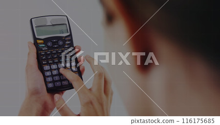 Image of a young caucasian professional, holding calculator, focusing on numbers Image of a young caucasian professional, holding calculator, focusing on numbers 116175685