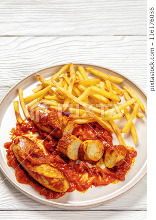 pork sausages in a curry sauce with french fries pork sausages in a curry sauce with french fries 116176036