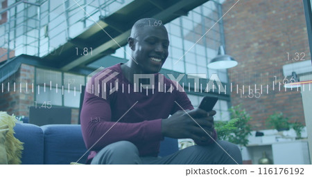African American colleague smiles, seated, using phone in modern living room 116176192