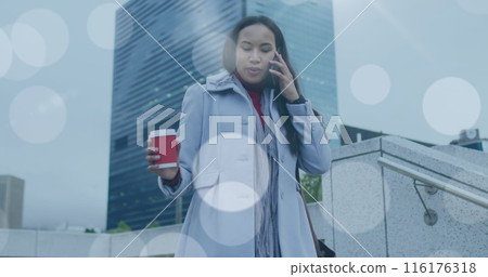 Image of lens flare over biracial woman walking to work, using smartphone in street Image of lens flare over biracial woman walking to work, using smartphone in street 116176318