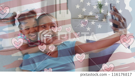 Image of flag of usa and hearts over african american woman and her daughter taking selfies 116176817