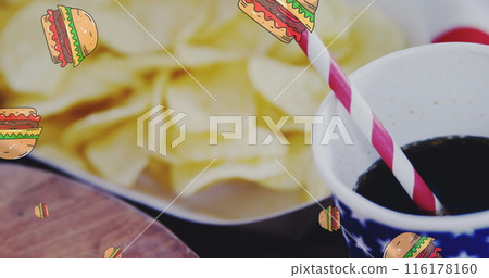 Potato chips resting in bowl, a soda with a striped straw nearby 116178160