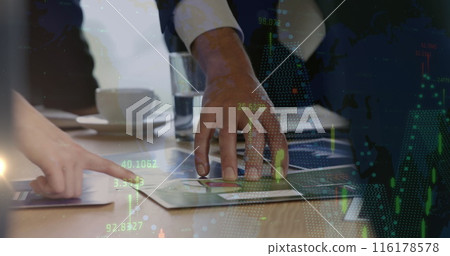 Two people wearing business attire are examining documents on table 116178578