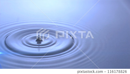 Image of water drops dropping into blue water with glowing light 116178826