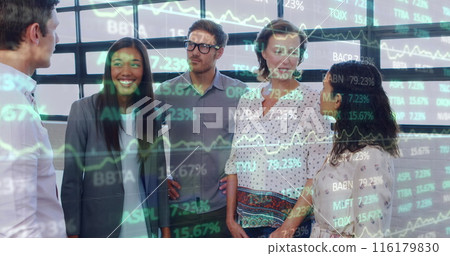 Image of trading board over diverse happy colleague discussing while standing in office 116179830