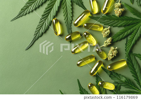 CBD Oil Capsules with Hemp Leaves on Green Textured Background with copy space CBD Oil Capsules with Hemp Leaves on Green Textured Background with copy space 116179869