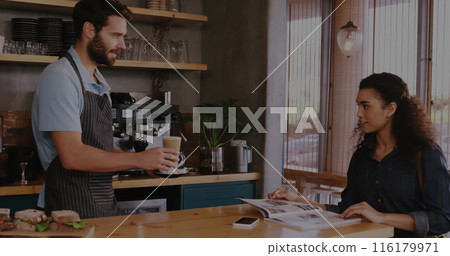 Caucasian male colleague serving coffee, biracial female colleague reading Caucasian male colleague serving coffee, biracial female colleague reading 116179971