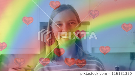 Image of heart emojis and rainbow flag over caucasian woman smiling 116181350