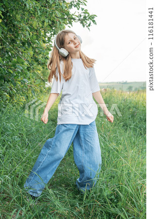 A child with headphones listening to music and dancing A child with headphones listening to music and dancing 116181441