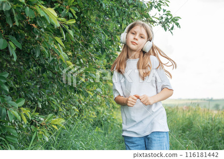A child with headphones listening to music and dancing A child with headphones listening to music and dancing 116181442