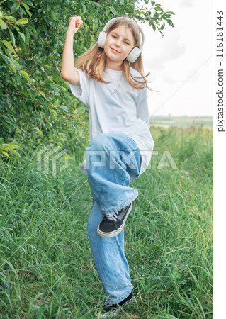 A child  with headphones listening to music and dancing 116181443