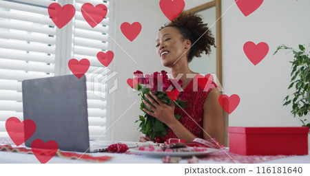 Image of heart icons over african american woman using laptop for image call Image of heart icons over african american woman using laptop for image call 116181640