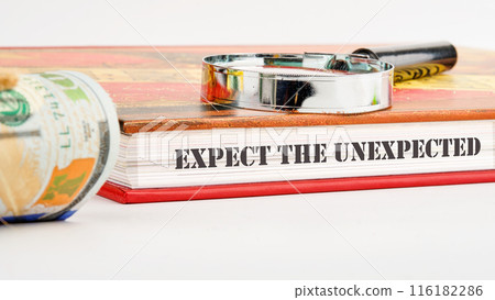 Expect The Unexpected word on the end of the book on a white background and compositions with a magnifying glass and money 116182286