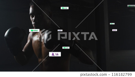 African American man wearing boxing gloves, training in dark gym African American man wearing boxing gloves, training in dark gym 116182799