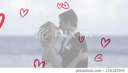 Caucasian couple wearing wedding attire, kissing on beach Caucasian couple wearing wedding attire, kissing on beach 116183045