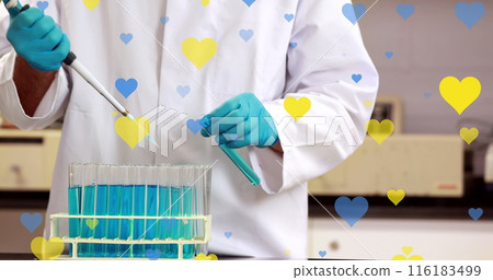 Image of yellow and blue hearts falling over midsection of biracial male lab worker 116183499