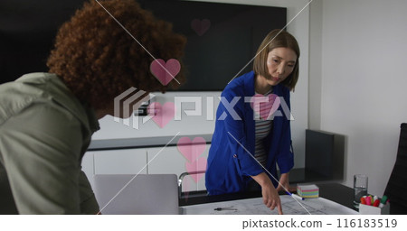 Image of hearts falling over diverse women using laptop 116183519