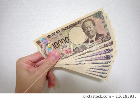 A person's hand holding new banknotes on a white background 116183933