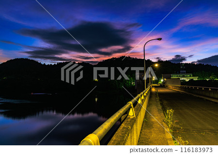 Evening scenery at Nunome Dam in the summer of 2024: From golden hour to blue hour, sunset over the dam embankment Evening scenery at Nunome Dam in the summer of 2024: From golden hour to blue hour, sunset over the dam embankment 116183973