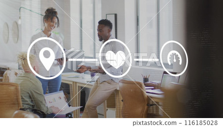 Image of icons connected with lines over diverse coworkers sharing ideas in office 116185028