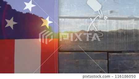 American flag and dog tags resting on rustic wooden surface, symbolizing patriotism 116186050