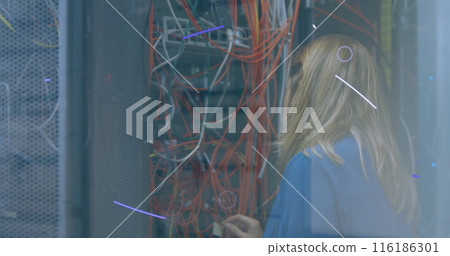 Caucasian woman wearing blue shirt, examining server cables 116186301