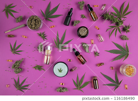 Cannabis leaf with oil bottle and hemp seeds on a pink background 116186490