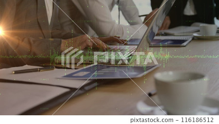 Caucasian team analyzing data on laptops, discussing strategies 116186512