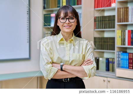 Portrait of confident elegant mature business woman in library Portrait of confident elegant mature business woman in library 116186955