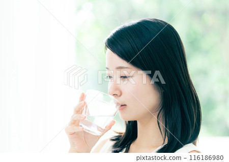 A woman drinking water 116186980