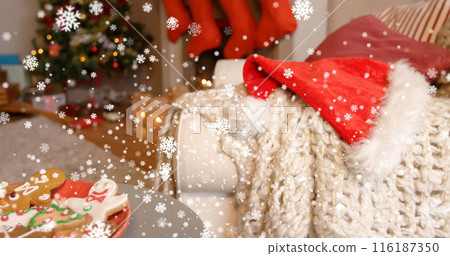 Image of digital snowflakes falling on santa hat and sweater on sofa at home during christmas Image of digital snowflakes falling on santa hat and sweater on sofa at home during christmas 116187350