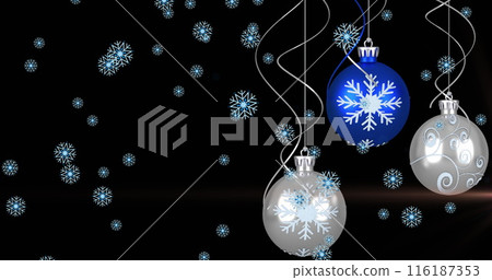 Image of snow flakes falling over hanging bauble decorations and light spot on black background 116187353