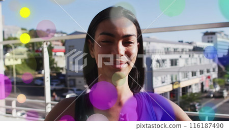 Image of glowing lights over biracial woman practicing yoga 116187490