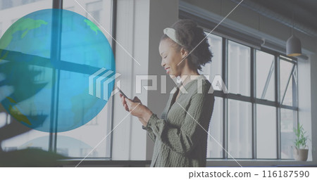 Image of globe over african american businesswoman using smartphone at office 116187590