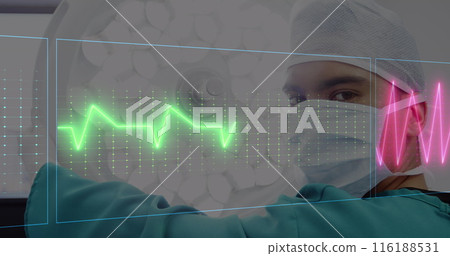 Middle Eastern male doctor in mask reviews digital heart rate monitors 116188531