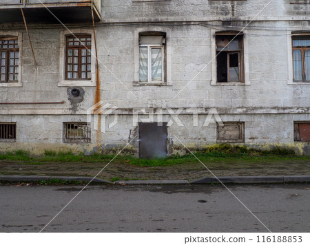 Facade of an old house. Gray wall with windows. Vintage architecture. 116188853