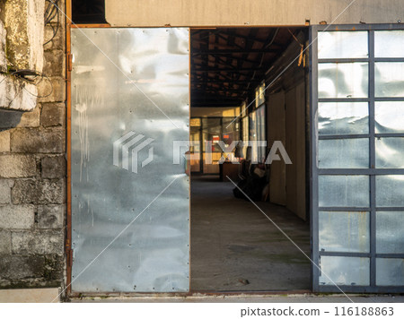 Open metal door. Double door. Entrance to a spacious room. 116188863