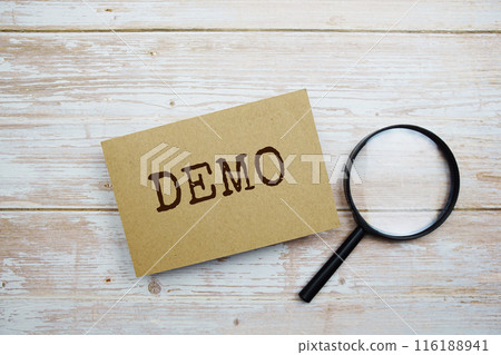 Demo text message and magnifying glass with space copy on wooden background Demo text message and magnifying glass with space copy on wooden background 116188941