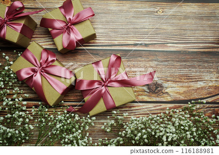 Gift boxes with pink ribbon and flower decoration on wooden background 116188981