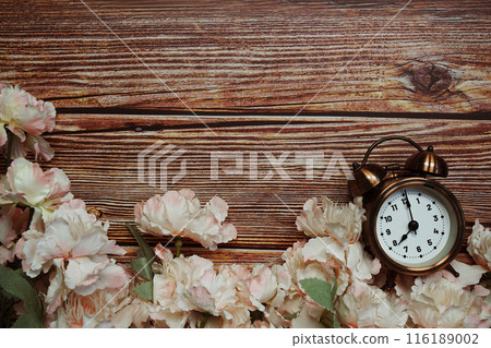 Space copy background with alarm clock and flower decoration on wooden background Space copy background with alarm clock and flower decoration on wooden background 116189002