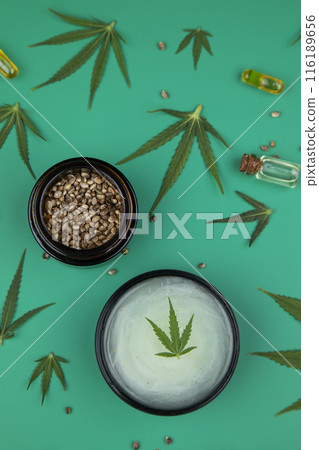 Flat lay composition of marijuana and hemp seeds on green color paper background Flat lay composition of marijuana and hemp seeds on green color paper background 116189656