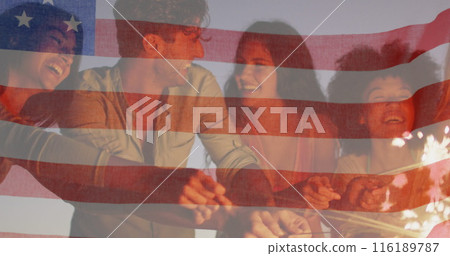 American flag waving against group of friends enjoying with sparklers at the beach 116189787